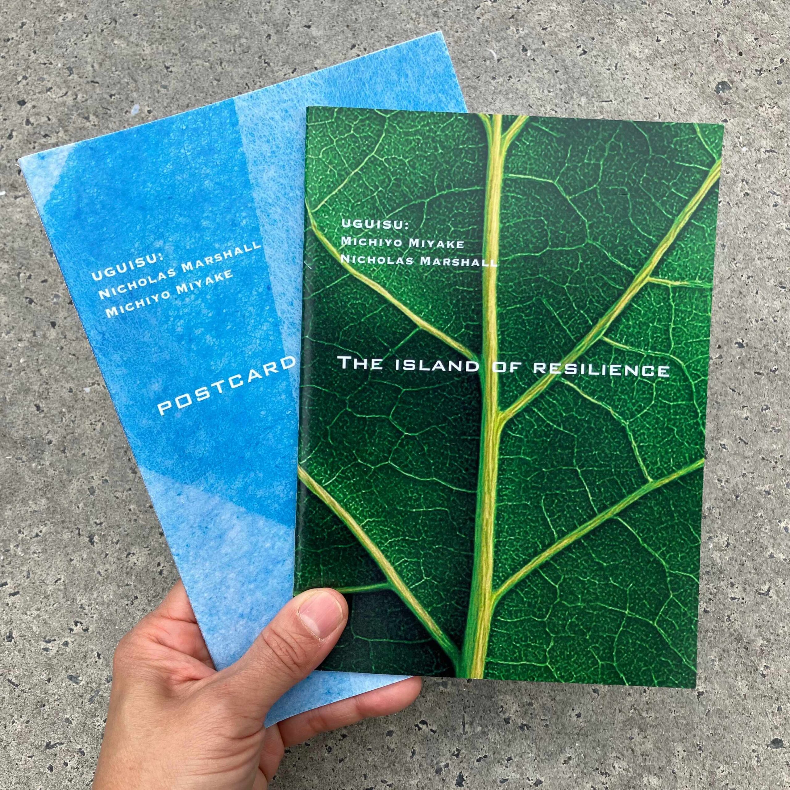Uguisu’s travel essay series volumes 1 and 2 held in a hand