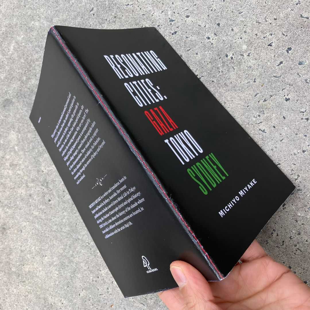 Close-up of the red machine-sewn spine of Michiyo Miyake’s poetry and visual zine Resonating Cities: Gaza, Tokyo, Sydney