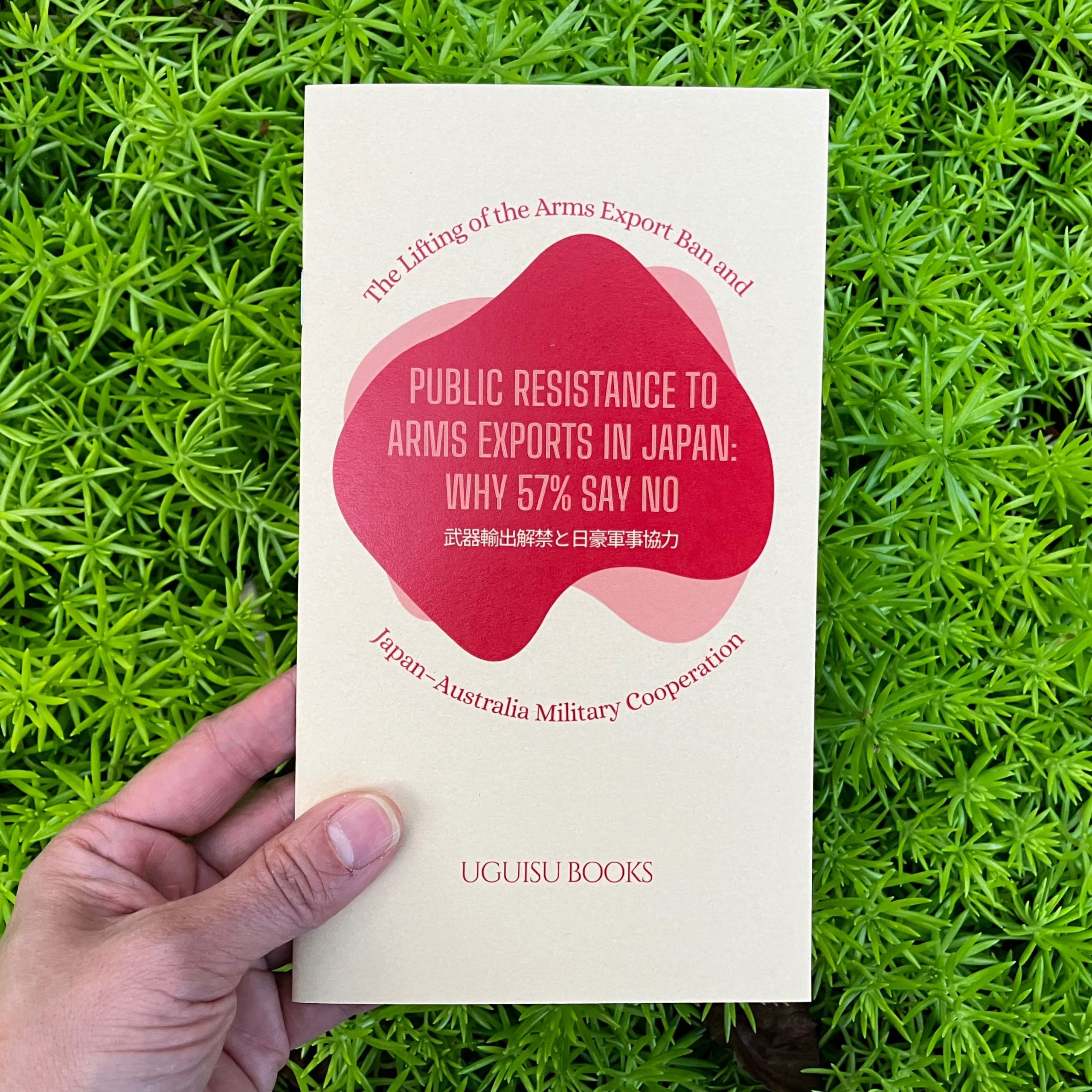 Zine, Public Resistance to Arms Exports in Japan: Why 57% Say No, held against a background of green plants